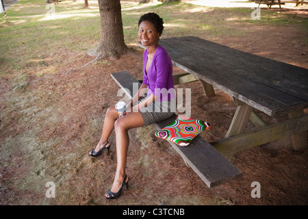 Afrikanische amerikanische Geschäftsfrau mit Laptop auf Picknickbank sitzen Stockfoto