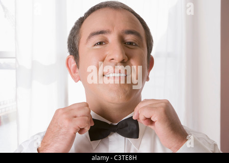 Hispanic Mann binden Fliege Stockfoto