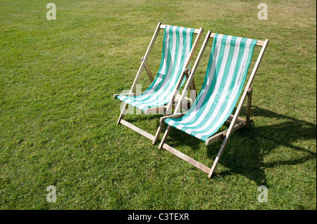 Zwei Liegestühle auf einer Grünfläche im Hyde Park, London. Stockfoto