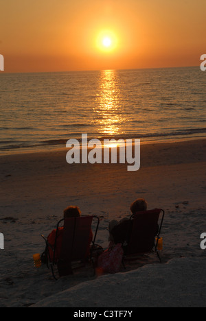 Die Sonne geht da zwei Leute zu beobachten, dass die Sonne St. Pete Beach, Florida eingestellt. Stockfoto