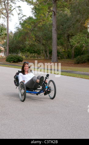 Frau, die Spaß beim Fahren der neueste grünen Maschine fordert Terre Trike Liegerad Dreirad um Straße für Aufregung Stockfoto