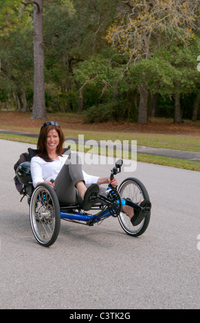 Frau, die Spaß beim Fahren der neueste grünen Maschine fordert Terre Trike Liegerad Dreirad um Straße für Aufregung Stockfoto