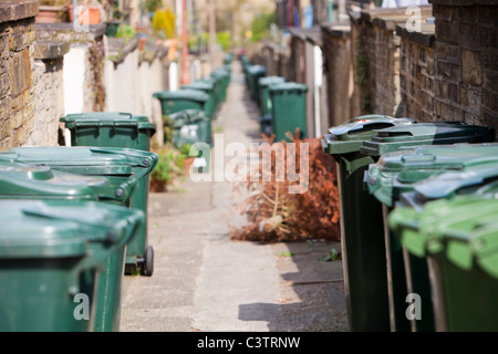 Mülleimer auf einer Seitengasse zwischen Reihenhäusern in Saltaire, Yorkshire, Großbritannien. Stockfoto