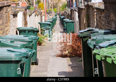 Mülleimer auf einer Seitengasse zwischen Reihenhäusern in Saltaire, Yorkshire, Großbritannien. Stockfoto