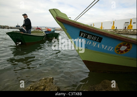Mann auf traditionellen hölzernen Fischerboot Ankunft am Hafen in Portugal Stockfoto