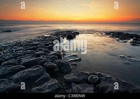 Sonnenuntergang über den Bristolkanal gesehen von den dramatischen felsigen Ufern des Nash Point in Südliches Wales Stockfoto