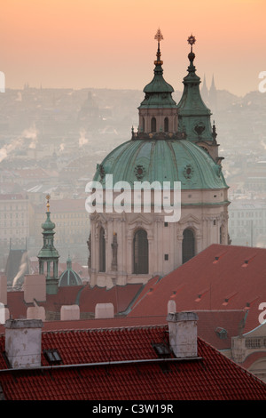 Sonnenaufgang über Prag mit der reich verzierten Kuppel der Kathedrale St. Nikolaus auf der Kleinseite Stockfoto