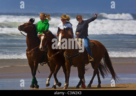 Drei junge Frauen reiten auf dem Sand Oceano State Beach, Oceano, California Stockfoto