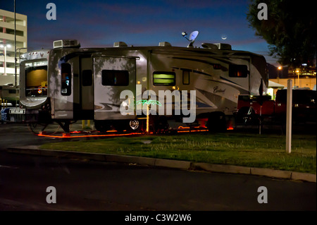 Nachtzeit erschossen 5. Rad-Karawane, dekoriert mit Lichtern und einer Palme in einem Las Vegas RV Park. Stockfoto