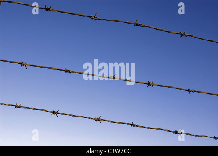 Abgeschnittenen Drahtzaun mit dunkelblauen Himmelshintergrund. Stockfoto