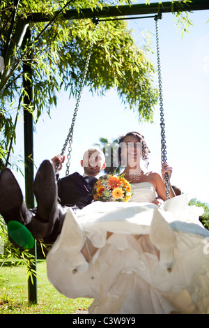 Foto von einem frisch verheiratete Paare, die Spaß auf einer Schaukel im freien Stockfoto