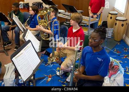 Anglo, bereiten Hispanic und Afro-Amerikaner Mittelschüler / innen, Blechblasinstrumente während Orchester Klasse spielen Stockfoto