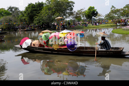 Mann verkaufen Regenschirme aus seinem kleinen Boot, Suan Luang Rama 9 Park, Bangkok, thailand Stockfoto