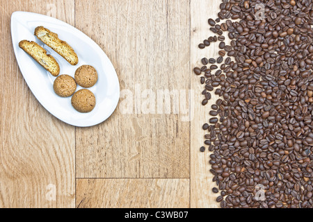 Kaffeebohnen auf Holzplatte mit Cookies auf ein weißes Stockfoto