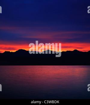 Ein atemberaubend brillante Sonnenaufgang über den Bergen und dem Wasser des Lake Mead an der Grenze zwischen Nevada und Arizona, USA Stockfoto