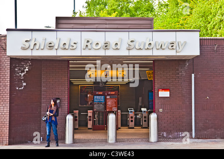 Junge Frau vor dem Eingang zum Schilde Road u-Bahnstation auf Glasgow u-Bahn Strecke. Stockfoto