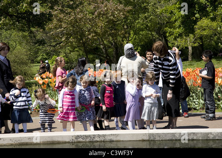 Orthodoxe jüdische Mädchen auf einem Schulausflug in der Brooklyn Botanic Garden, Blick auf die Goldfische in den Seerosenteich. Stockfoto