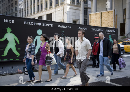 Die Menschen gehen durch eine temporäre Wand auf einer Baustelle in der Innenstadt von Manhattan. Stockfoto