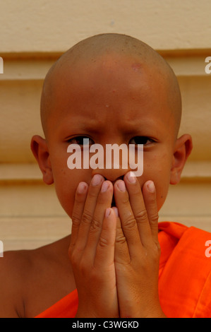 Junge Anfänger tut die drei weisen Affen, sprichwörtliche Prinzip während der Ordination Zeremonie, Wat Santithammaram, Bangkok, thailand Stockfoto