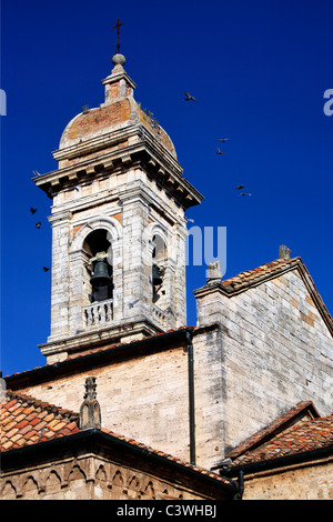 Ein Schwarm Tauben fliegen vom Glockenturm der Stiftskirche des Heiligen Quiricus & Julietta in San Quirico D'Orcia, Italien Stockfoto