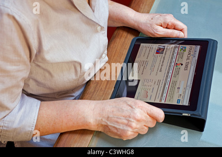 Geschäftsfrau, die Online-Ausgabe der Financial Times auf einem Tablet PC lesen Stockfoto