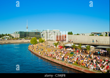 Menschen, die zum Sonnenbaden im Beachclub und Bar am Ufer der Spree, Berlin-Mitte Stockfoto