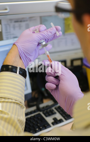 Der Arzt verabreicht vor der Verabreichung an einen Patienten einen Impfstoff in eine hypodermische Spritze. Stockfoto