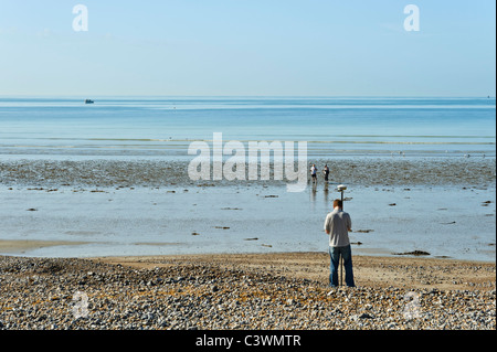 Ein Umfrage-Team mit GPS-Geräten arbeitet an Worthing Strand in der Morgensonne Stockfoto