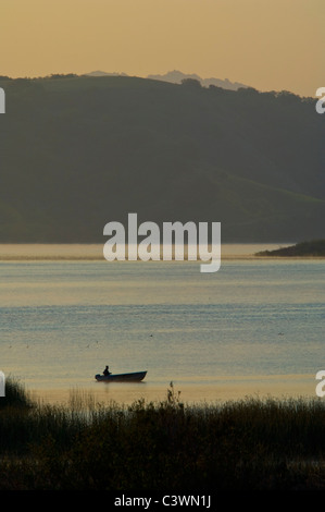 Fischer in kleinen Boot im Morgenlicht in Lake Casitas, in der Nähe von Ojai, Kalifornien Stockfoto