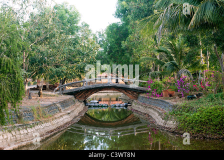 Kleiner Stein Brücke über einen kleinen Teich in einem resort Stockfoto