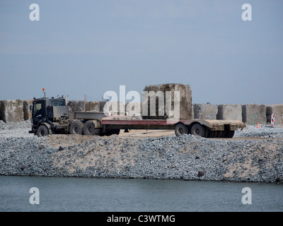 Tieflader mit einem 40-Tonnen Beton Block, für eine Barriere in der Nordsee eingesetzt. Rotterdam-Niederlande Stockfoto