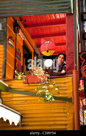 Dame am Balkon der bunt bemalten Gebäude Caminito in La Boca Bezirk, Buenos Aires, Argentinien, Südamerika. Stockfoto