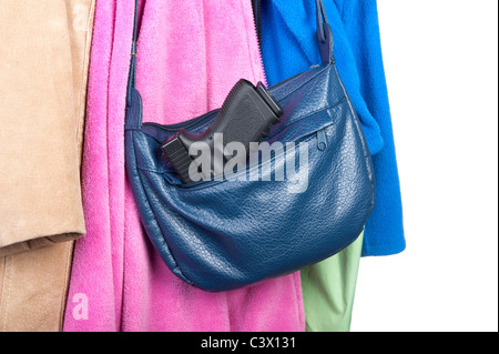 Eine Frau Handtasche hängen eine Garderobe mit einem Gewehr in der Seitentasche. Stockfoto