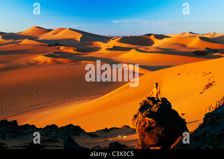 Algerien, Djanet. Sanddünen und Felsen. Frau zu meditieren. Wüste Sahara. Stockfoto