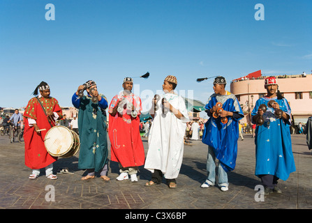 Musiker in traditioneller Kleidung unterhalten Touristen und Einheimische auf dem Marktplatz Djemaa el Fna. Marrakesch, Marokko. Stockfoto