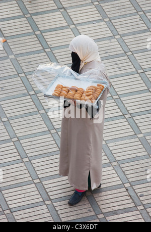 Frau verkaufen Cookies auf dem Marktplatz Djemaa el Fna. Marrakesch, Marokko. Kein Model-Release. Stockfoto