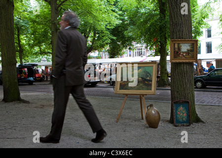 Mann zu Fuß vom Kunstwerk zum Verkauf am Sonntag Antikmarkt den Haag Stockfoto