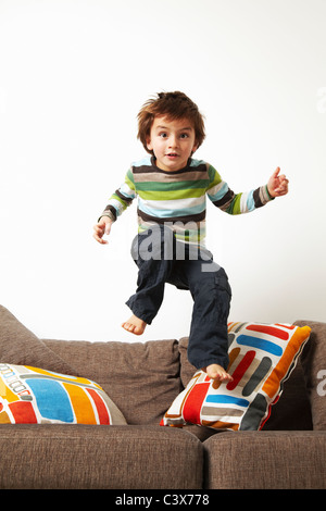 Junge auf Sofa springen Stockfoto