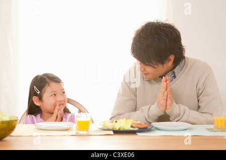 Vater und Tochter Beten am Frühstückstisch Stockfoto