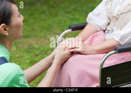 Sozialarbeiter Holding Senior Frau Hände Stockfoto