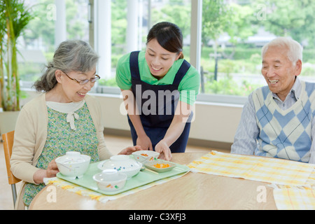 Krankenschwester mit Speisen zu den älteren Frau Stockfoto