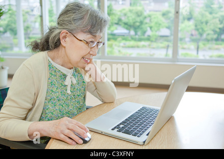 Ältere Frau mit Laptop, der Präfektur Kanagawa, Honshu, Japan Stockfoto