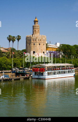 Ein Touristen-Kreuzer vor Anker vor dem Torre del Oro oder Goldener Turm, in Sevilla, Andalusien, Spanien. Stockfoto