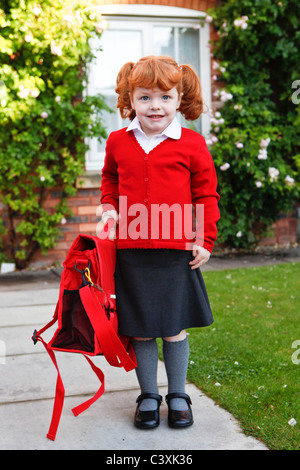 Ein 4 Jahre altes Mädchen mit Ingwer Haare auf ihren ersten Schultag. Stockfoto