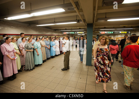 Mitglieder der mennonitischen Kirche singen Hymnen und ohnmächtig werden Broschüren, wie sie in der u-Bahn in New York missionieren Stockfoto