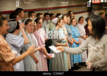 Mitglieder der mennonitischen Kirche singen Hymnen und ohnmächtig werden Broschüren, wie sie in der u-Bahn in New York missionieren Stockfoto