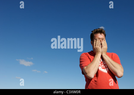 Ein Mann hält seinen Kopf Stockfoto