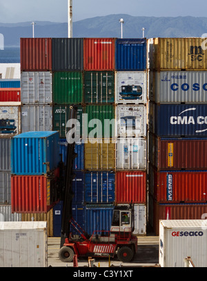 Ein Stapel von farbigen Container an den Docks in Wellington, New Zealand, mit einem roten LKW fahren vor Ihnen Stockfoto