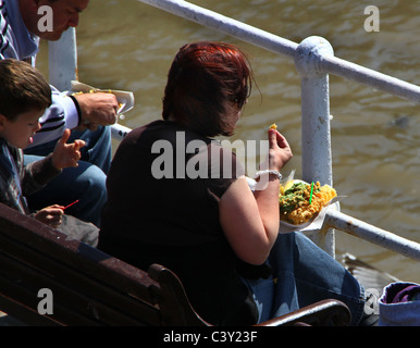 Menschen essen Fisch und Chips am Meer. Stockfoto