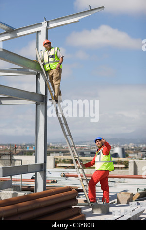 Arbeiter auf Leiter stehend Stockfoto